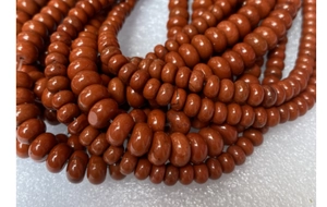 Macro shot of polished reddish-brown abacus-shaped jasper stone beads for DIY jewelry