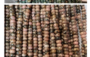 Close-up of pink rhodonite abacus beads with natural black veins for jewelry making