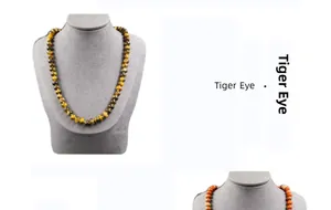 Detailed view of natural tiger eye stone beaded necklace on a grey velvet display mannequin
