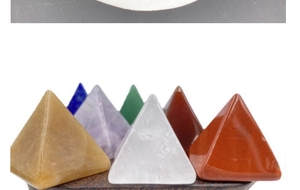 Ensemble détaillé de sept pyramides en cristal de chakra sur un socle en bois sombre