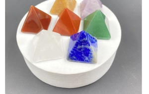 Vue macro de pyramides en pierres naturelles de guérison sur un plateau en blanc
