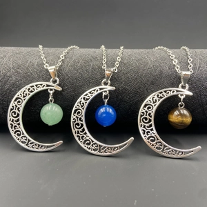 Collier pendentif demi-lune évidé avec pierres naturelles sur un présentoir noir
