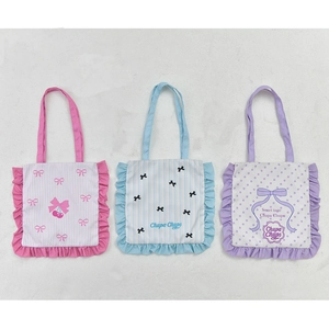 Detailed view of ruffled canvas tote bags in pink, blue, and purple with bow accents