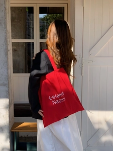 Detailansicht einer großen roten Segeltuch-Einkaufstasche mit Island Naomi Aufdruck