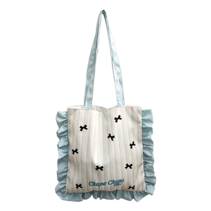 Blue striped canvas tote bag with black bows and decorative ruffle trim edges