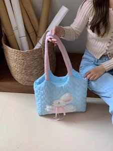 Detail of light blue heart-quilted canvas tote with plush 3D bunny and pink handles