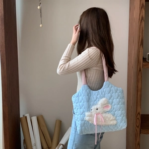 Blue quilted tote bag featuring plush bunny embroidery and pink shoulder straps