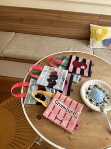 Detailopname van diverse mini canvas handtassen met cartoon kattenprint op een cafétafel