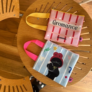 Detail van stoffen mini tasjes met kleurrijke handvatten en schattige cartoons