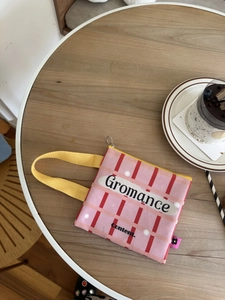 Detailopname van een kleine roze geruite canvas handtas met een geel handvat