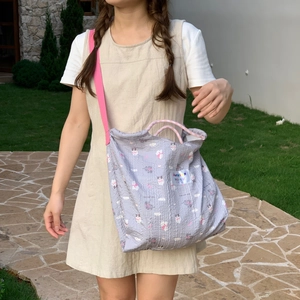 Detail of grey quilted canvas bag with pink straps and cute cartoon animal prints