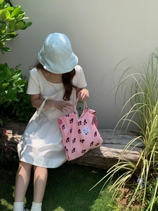 Pink puffy fabric tote bag with cute patterns shown in an outdoor lifestyle setting