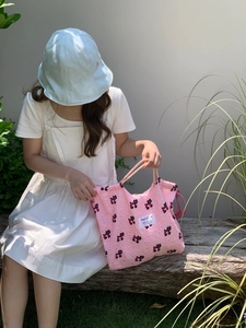 Detail of pink puckered fabric tote with cute bear prints and showing mercy label