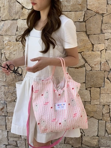 Detail of pink striped canvas bag featuring cartoon dog patterns and cherry prints