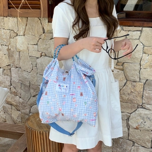 Detail of blue plaid canvas tote bag featuring cute cartoon bears and wide shoulder strap