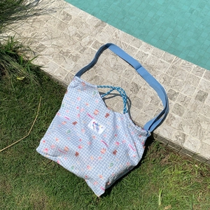 Detail of blue checkered canvas tote bag with sweet bear pattern and drawstring closure
