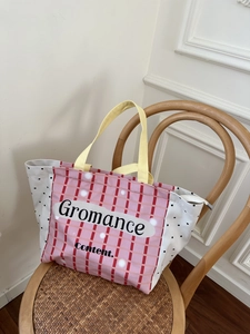 Canvas tote bag with pink check pattern and yellow handles on a vintage wooden chair