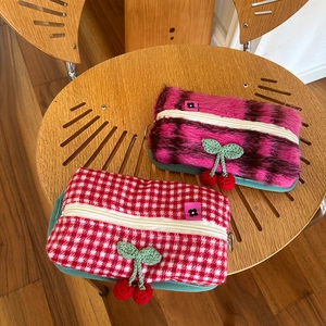 Détail de pochettes en peluche et vichy avec breloques cerises tricotées main