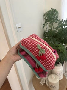 Détail de la pochette tricotée à carreaux rouges et blancs avec cerise en 3D