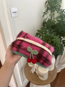 Détail de la trousse en peluche rayée rose avec une cerise faite à la main