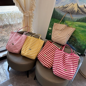 Selection of striped canvas tote bags in pink, yellow, red, and khaki colors