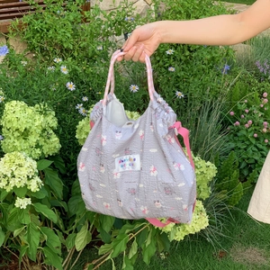 Purple bubble quilted tote bag with cute cartoon cats and showing mercy woven label
