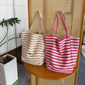 Striped canvas tote bag in khaki and rose colors with handmade leather patch detail