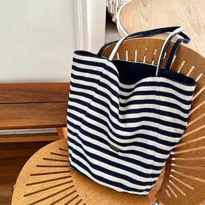 Striped canvas tote bag in navy and white with large capacity on a designer wooden chair