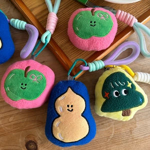Detail of embroidered plush bag charms with woven lanyards and metal buckles