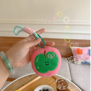 Detail of pink plush apple charm with embroidery smile and braided wrist strap
