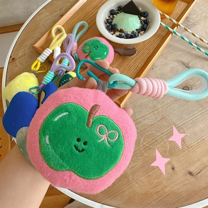 Detail of pink plush apple charm with embroidery, carabiner, and colorful rope handle