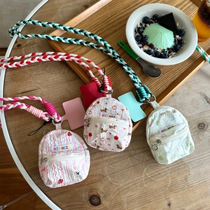 Detailed view of mini backpack earphone pouches with braided straps in assorted colors