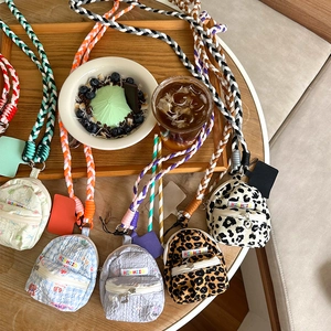 Mini backpack-shaped coin purses with colorful braided straps in various patterns