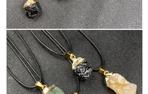 Detalle de colgantes de piedra natural con borde dorado y cordón en verde, negro y naranja