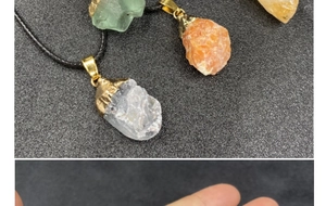 Detalle macro de colgantes de cristal natural con cierres dorados y cordón negro