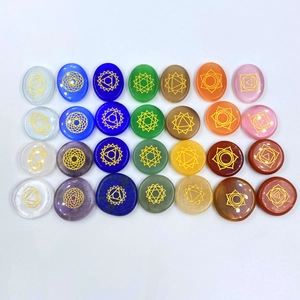 Primer plano de piedras de chakra con símbolos dorados sobre un fondo blanco puro