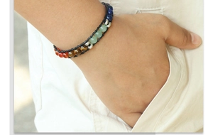 Détail des perles 7 Chakra sur bracelet en cuir noir tressé porté au poignet