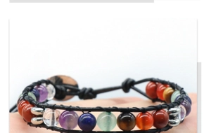 Gros plan d'un bracelet en cuir tissé avec des perles de pierres naturelles colorées