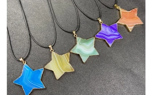 Detalle de colgantes de estrella en ágata listada azul, verde y púrpura con baño de oro