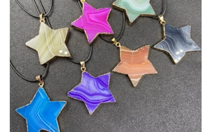 Detalle de colgantes de pentagrama de ágata colorida con elegantes bordes de metal dorado