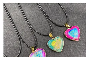 Detail of colorful heart-shaped stone pendants with gold-plated edges and black cords