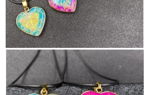 Macro detail of heart-shaped marble pendants with gold edges and natural mineral textures