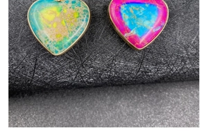 Macro detail of heart-shaped colorful imperial stone pendants with gold-plated edges