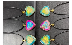 Macro detail of colorful heart-shaped stone pendants with gold-plated metal frames