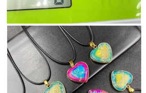Detail of colorful heart stone pendants with gold plated edges and black woven necklace cords