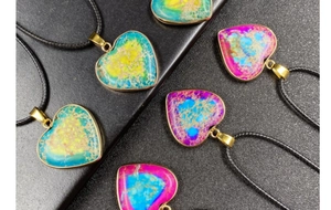 Macro detail of colorful imperial stone heart pendants with gold-plated edges and cords