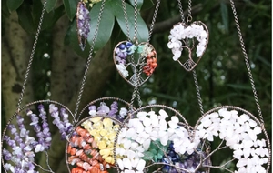 Detail of wire-wrapped tree of life heart pendants with natural crystal stones