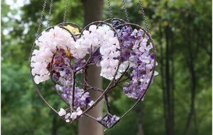 Detail of handmade wire-wrapped heart suncatcher with colorful natural healing crystal stones