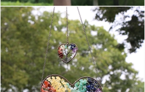 Detail of handmade heart-shaped dreamcatcher with colorful natural stone tree of life