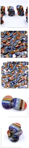 Macro detail of polished chakra palm stones with vibrant colorful layered stripes